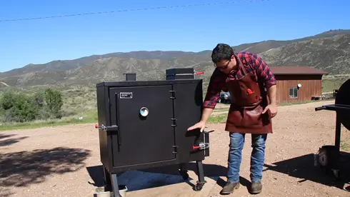 Gravity fed smoker cooking chamber
